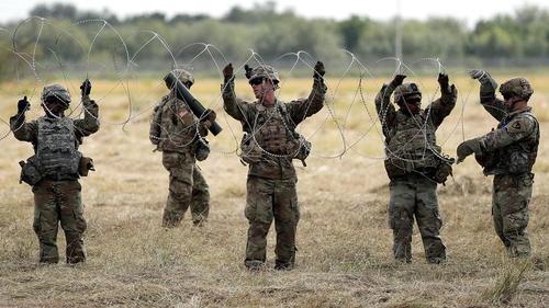 US Troops Lay Down Razor Wire At Southern Border