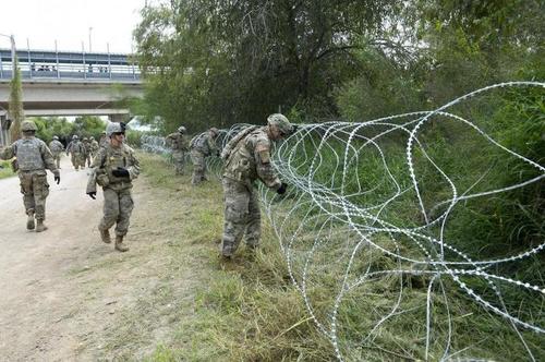 US Troops Lay Down Razor Wire At Southern Border