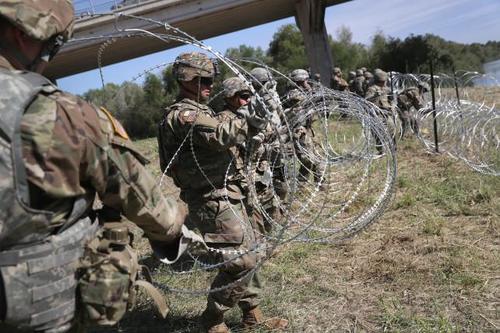 US Troops Lay Down Razor Wire At Southern Border